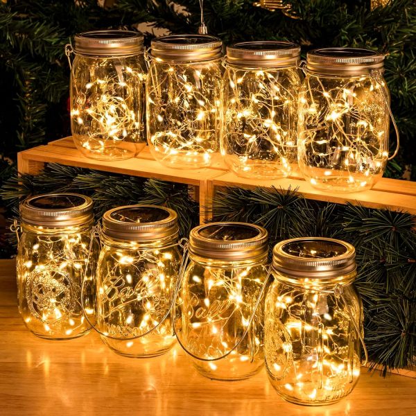 8 glass jars with string lights inside lit up