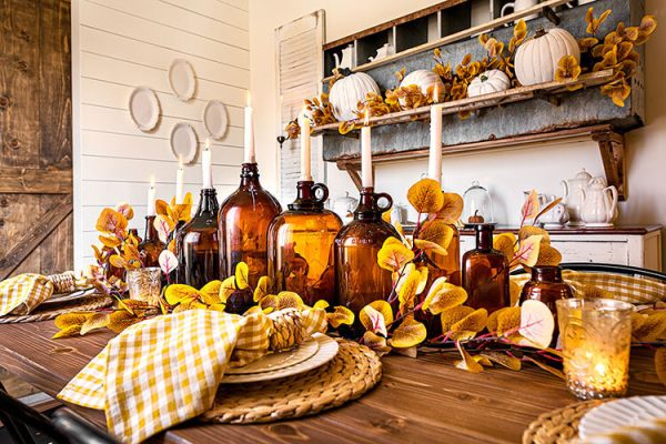 amber jugs with taper candles on a wood table with fall accents farmhouse fall decor