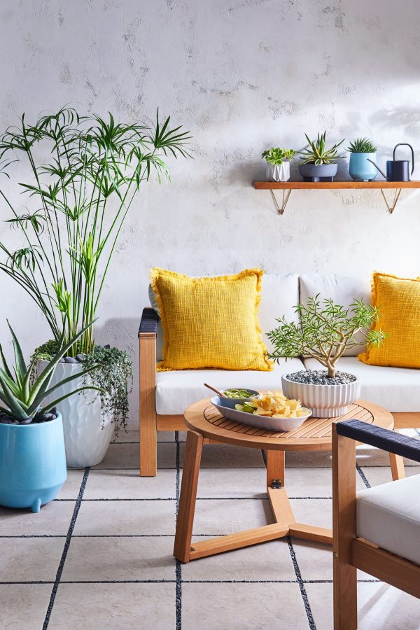 outdoor sofa with potted plants and yellow pillows infusing your home with summer vibes