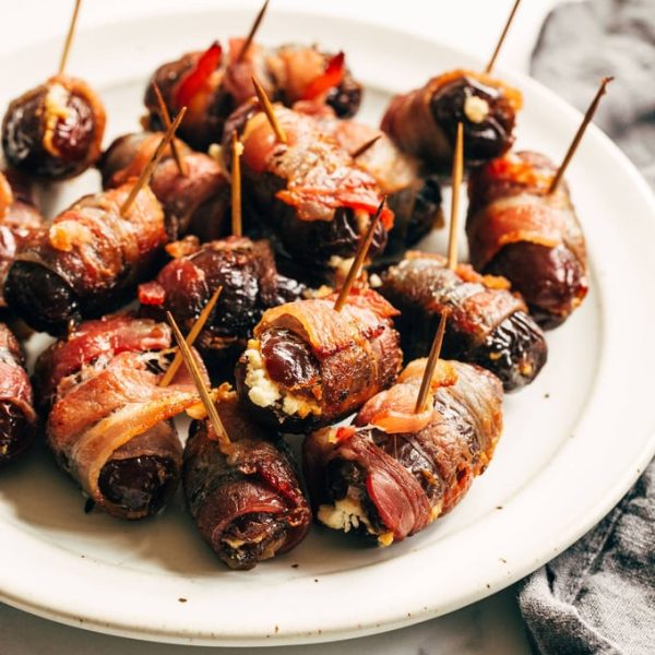 a white plate of bacon wrapped dates