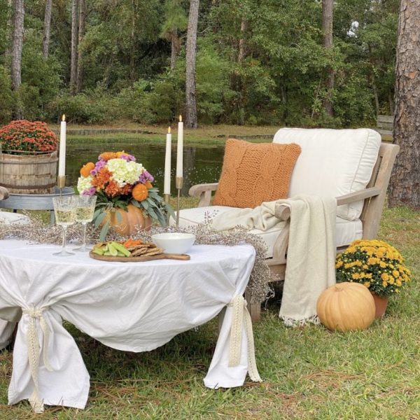 table and chair outside with fall accents and blankets fall potluck table