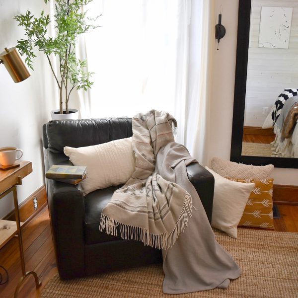 cozy chair with pillows and a blanket