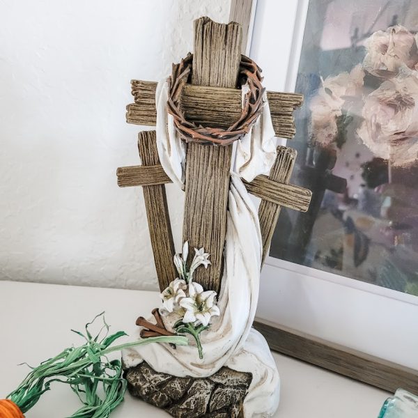 a statue of 3 crosses draped with a white cloth