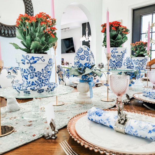 blue and white flower pots with red flowers on a dining room table set for dinner my Easter home tour