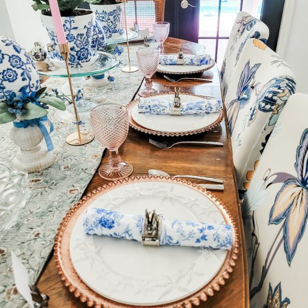 table set for dinner with white plates and blue and white napkins