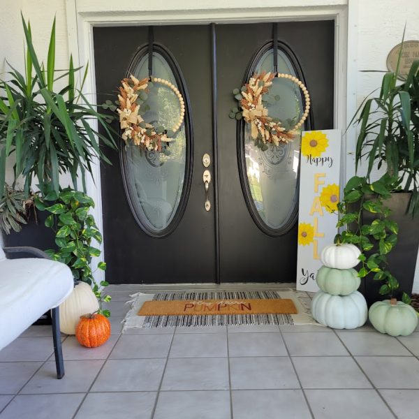 fall front porch with wood bead wreaths and faux pumpkins