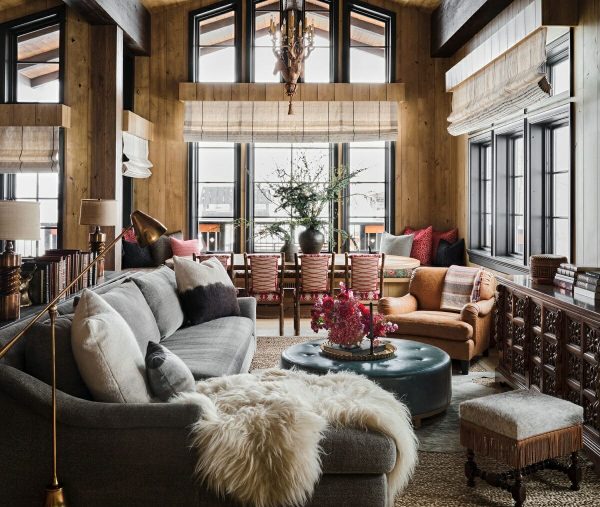 living room with high ceilings, ceiling to floor windows, leather furniture and a fur blanket