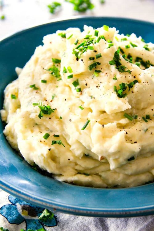 a blue dish of mashed potatoes with parsley on top great fall side dishes