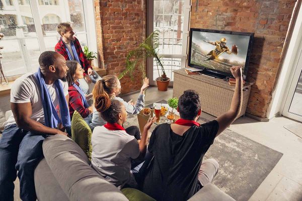 people sitting on a sofa watching television