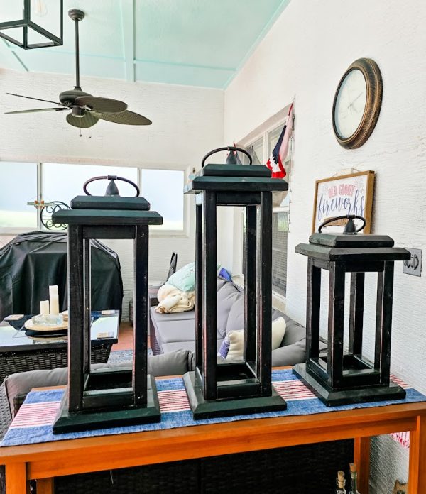 three black wooden lanterns on a table top