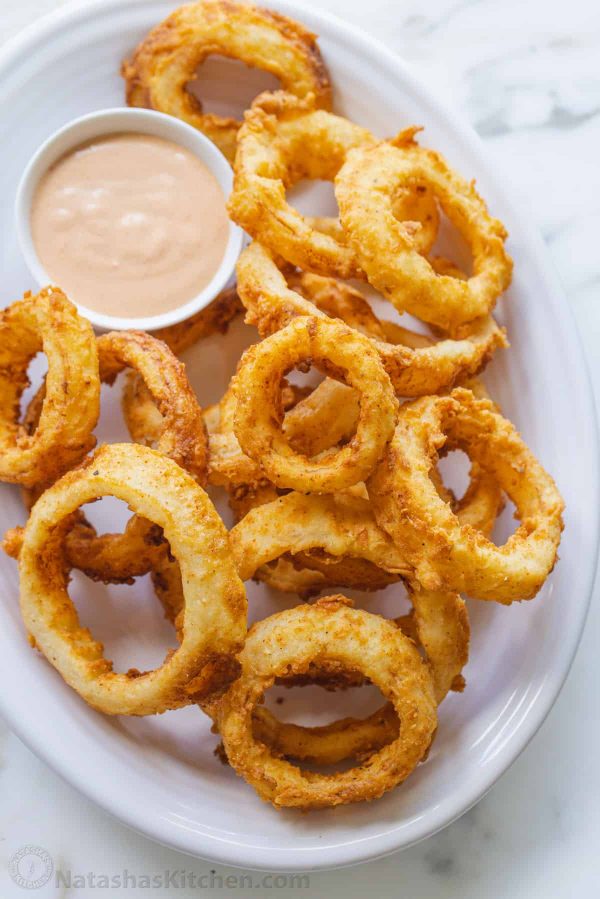 onion rings with dipping sauce on a plate