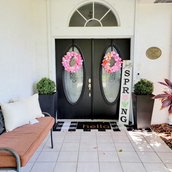 black double front doors with pink flower wreaths