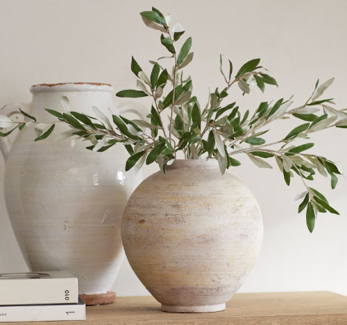 Two large stone vases one with and olive bundle in it. summer decorating for small spaces