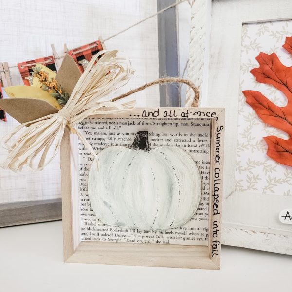 wooden frame with a wooden pumpkin painted and foliage