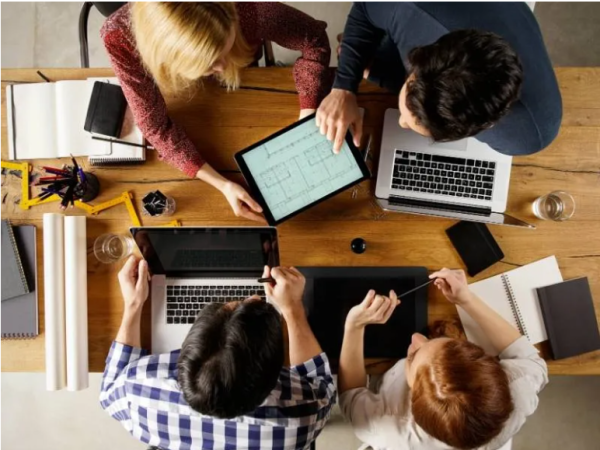 four people with computers having a meeting