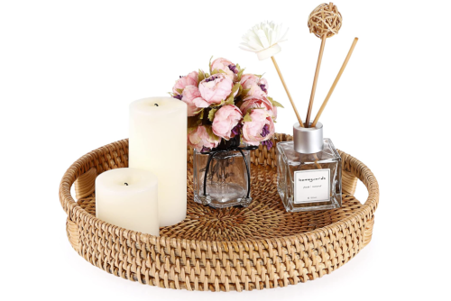 round wicker tray with a vase of flowers and candles