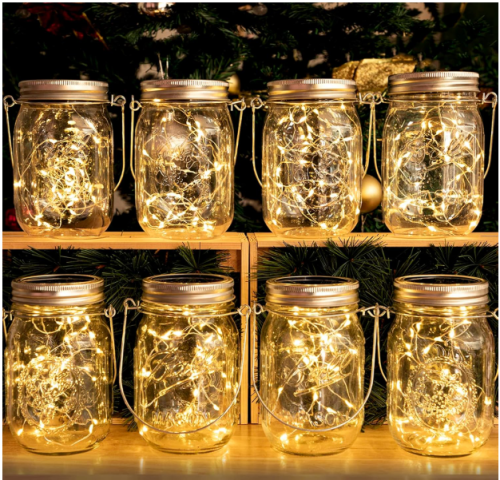 a set of 8 mason jars with string lights inside
