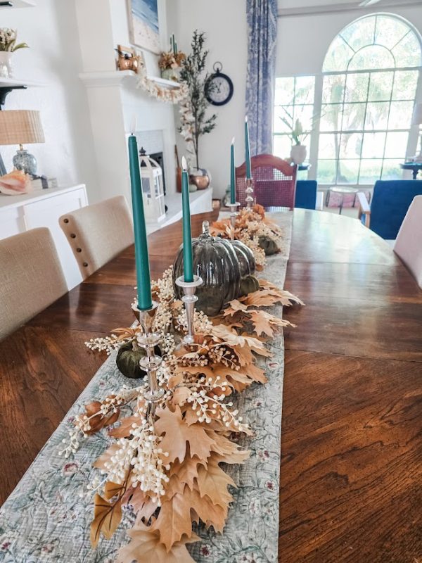 a fall table centerpiece with green candles