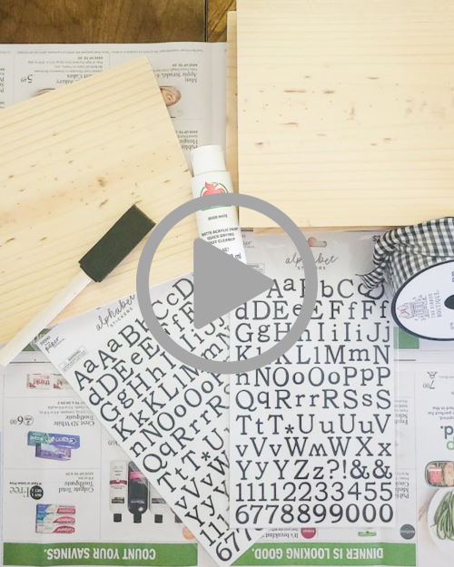 A table with wood and stickers laying on top make faux paperback books for your fall decor