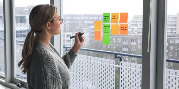 a woman placing sticky notes on a window