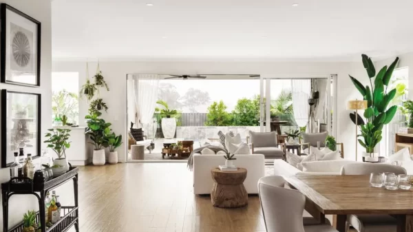 large white living room with wood floors, white furniture and large windows