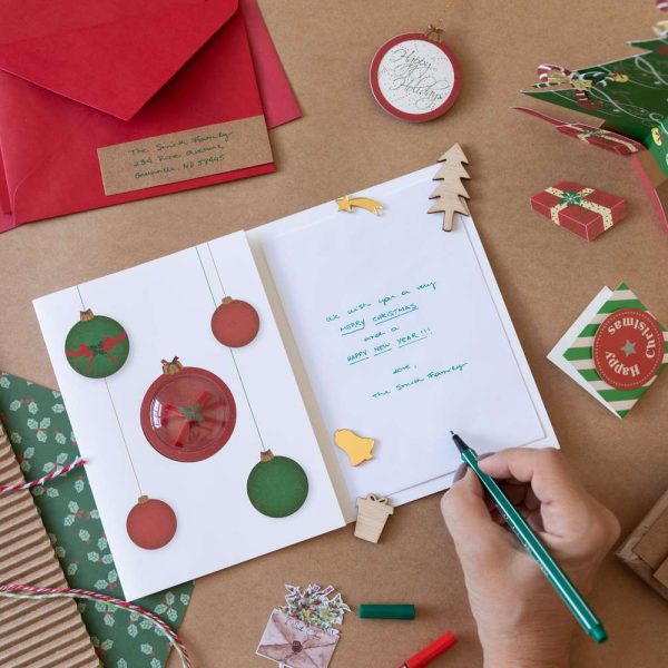 a person signing a Christmas card