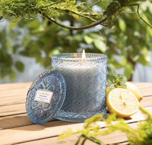 white candle in a blue glass jar