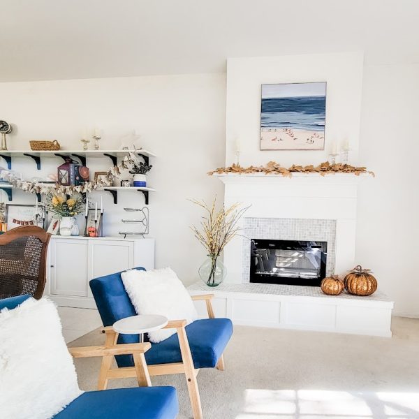 white living room with fireplace and blue velvet chairs