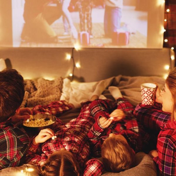 family watching a movie on a large screen Christmas