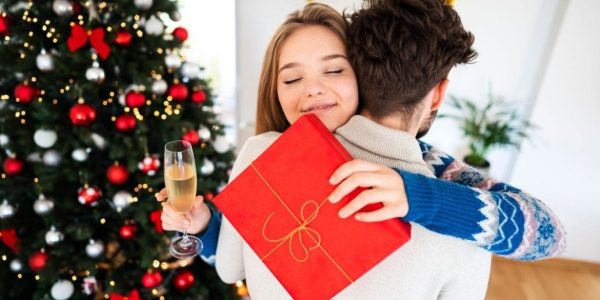 a couple hugging and giving gifts the best thing to give this Christmas