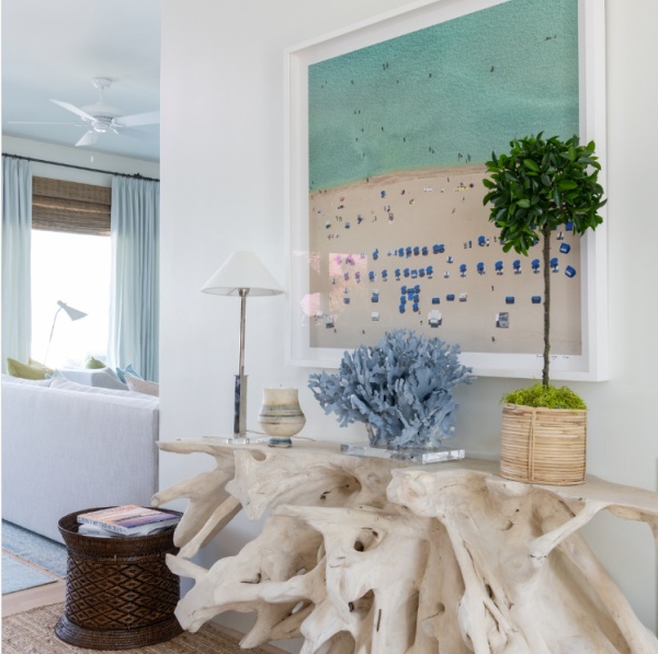 white living room with a large beach painting and a driftwood table