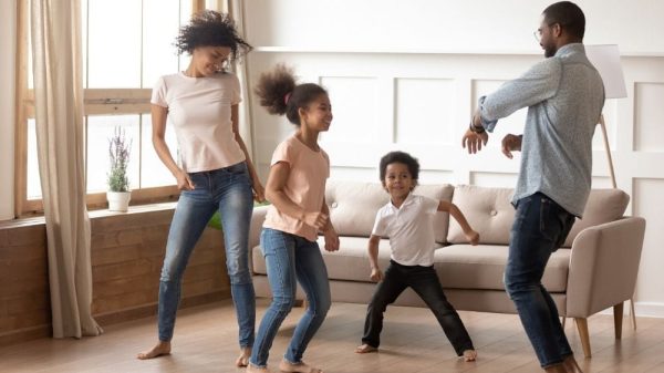 four people dancing in the living room