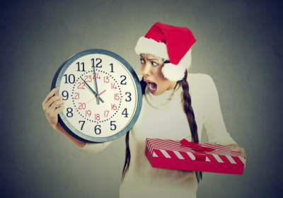 a person holding a clock and a Christmas present the art of holiday planning