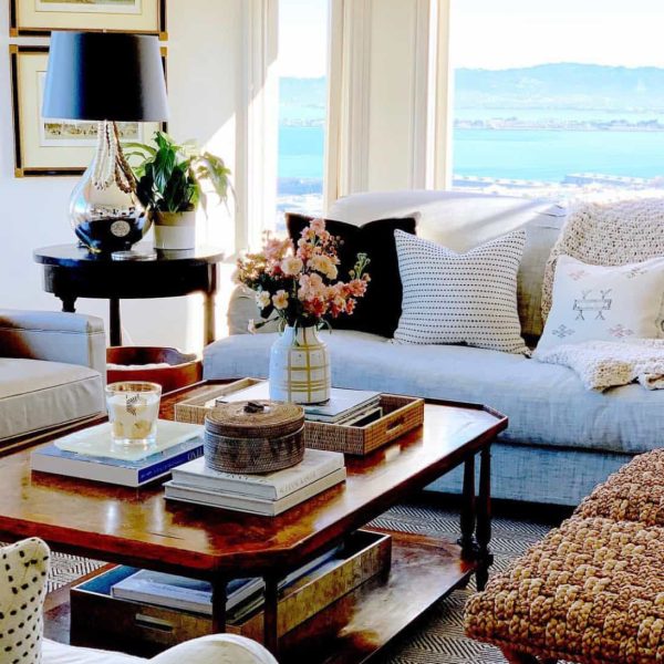 living room with books on the coffee table and a large window overlooking the lake embracing timeless style