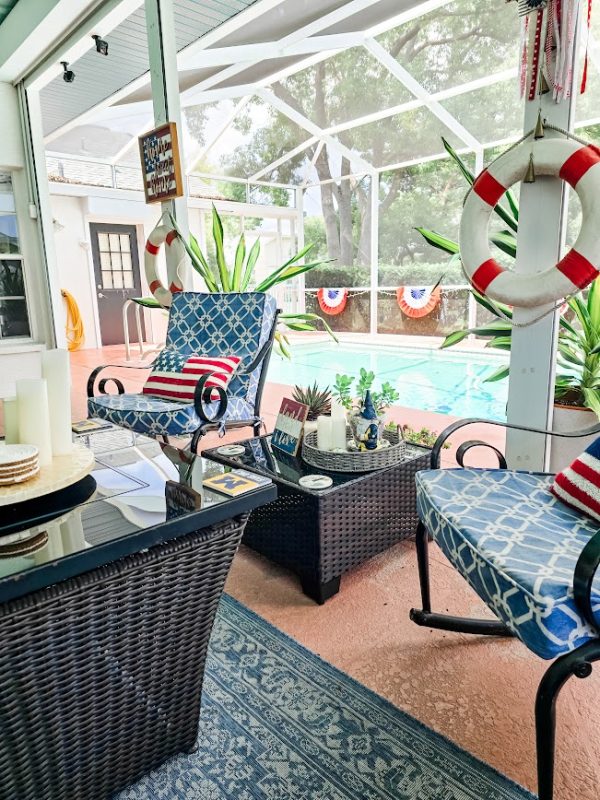 rocking chairs on a porch with a swimming pool and plants