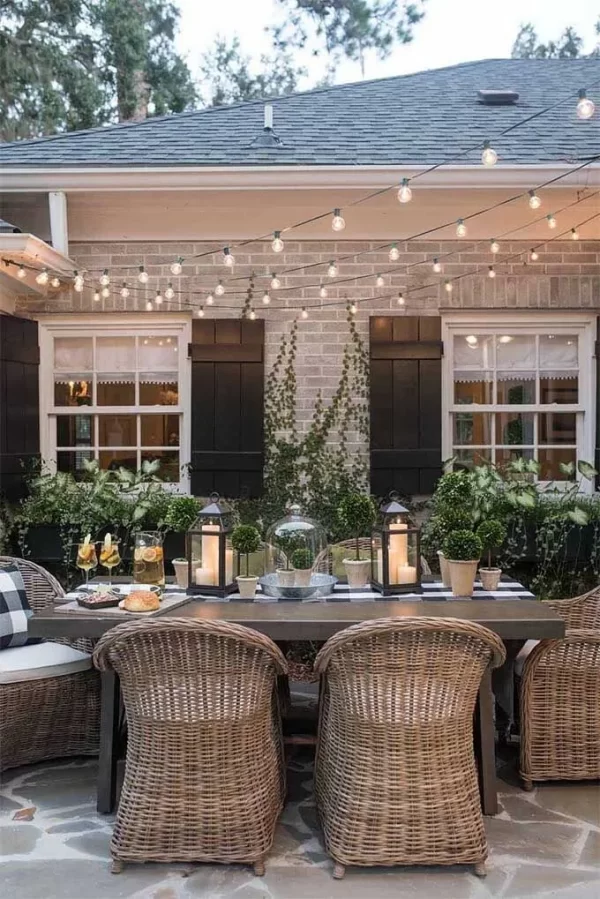 a patio with a dining area, string lights and lanterns