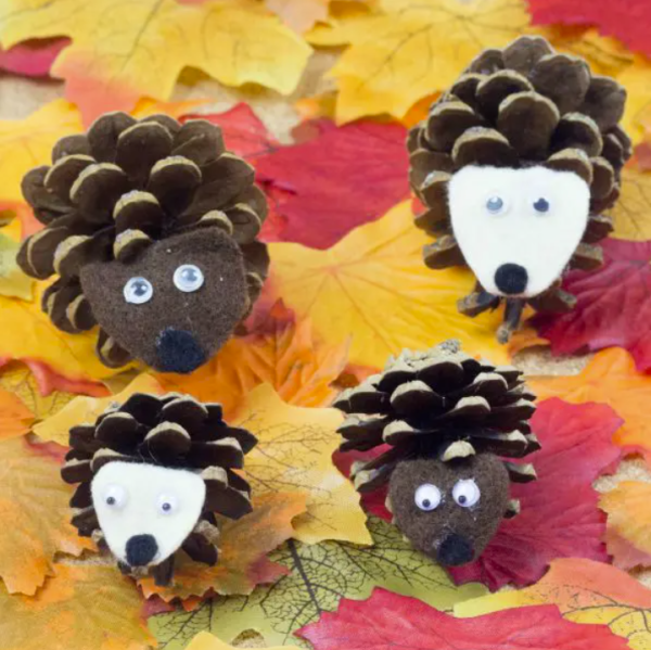 four pinecone animals on a background of leaves fall decor using children's crafts