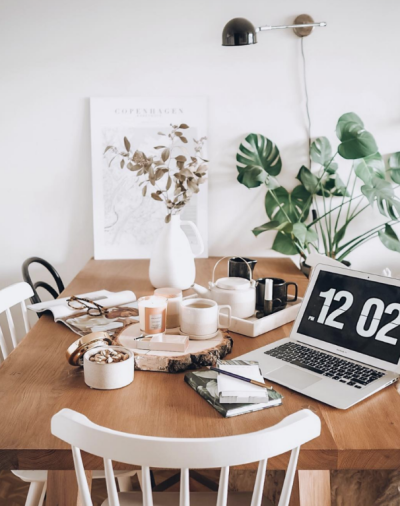 kitchen table with a laptop, vase of flowers and a cup of coffee the art of holiday planning