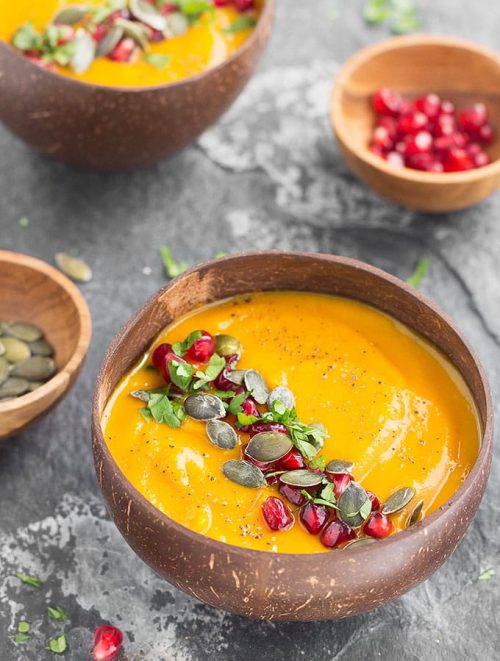 bowl of pumpkin apple soup with pumpkin seed garnish
