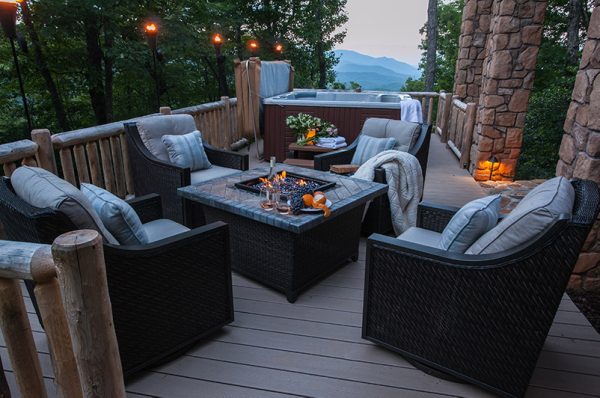 outdoor furniture on the deck of a cabin in the woods