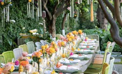 a garden party set up under the trees with yellow and pink roses