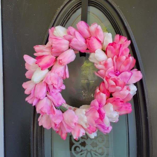 pink and white tulip wreath on a black door