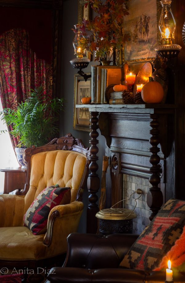 a dark sitting room with a black fireplace and kerosene lamps embrace fall vintage style
