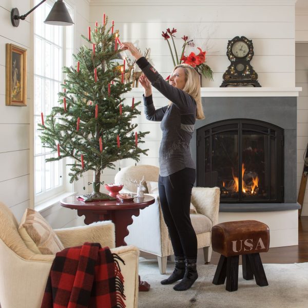 woman decorating a Christmas tree in her living room